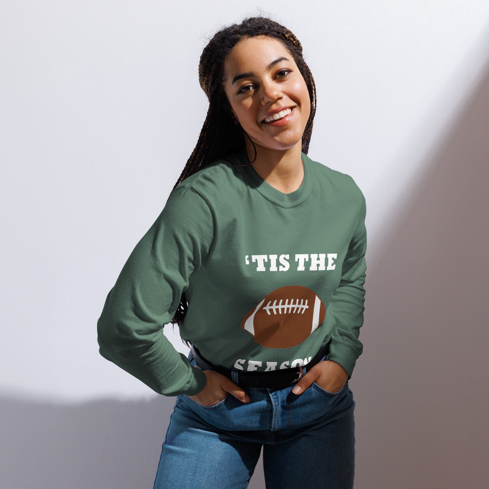 Person wearing a green long-sleeve shirt with a football graphic and text on a plain background